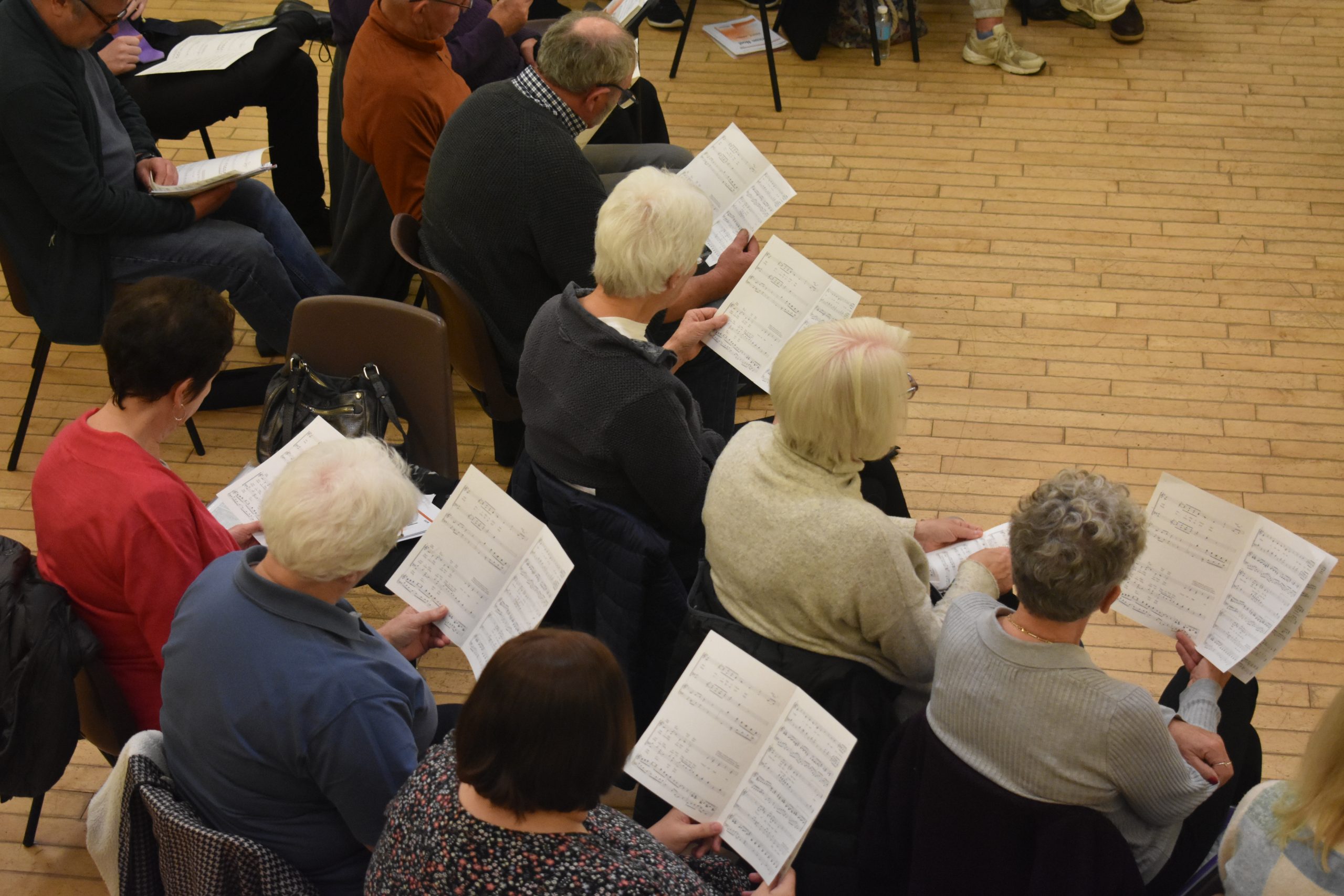 KTB Choir Soprano Section sitting reading Christmas music, viewed from above